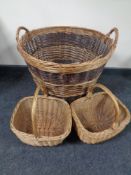 A large wicker twin-handled log basket together with two further wicker shopping baskets.