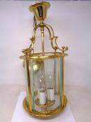 A contemporary brass cylindrical pendant light fitting.