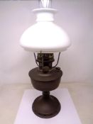 An Aladdin oil lamp with chimney and opaque glass shade.