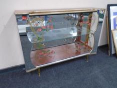 A mid-20th century walnut veneer sliding glass door display cabinet on raised legs.