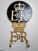 A cast iron Queen Elizabeth II wall plaque together with a two-hook coat rack.