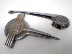 A mid-20th century Morris Minor bonnet ornament together with a Morris car badge.