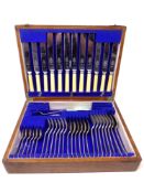 An Edwardian oak canteen of silver plated and stainless steel cutlery.