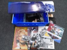 A box containing calendars, movie posters, black and white photographs etc.
