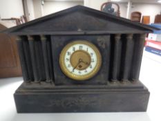 A 19th century black slate mantel clock with enamelled brass dial.