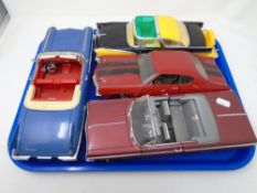 A tray containing four large scale die cast vehicles.