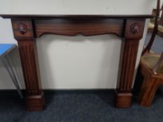 A contemporary fire surround in a mahogany finish.