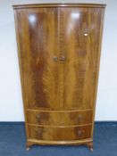 A 20th century Beithcraft Furniture flame mahogany bow fronted gentleman's wardrobe fitted with two