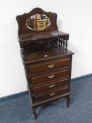 A 19th century mirror backed four drawer music chest
