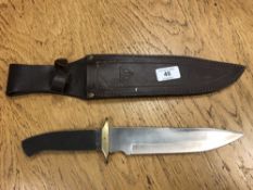 A bowie knife in leather sheath (lacks grip)