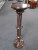 A barley twist plant stand in a mahogany finish