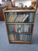 A set of oak sliding glass door bookcase with three shelves of hardback and softback books etc