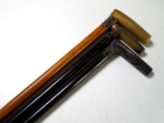 Three antique walking sticks, two with silver mounts.