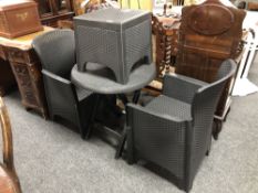 A circular plastic garden table together with matching armchairs and footstool