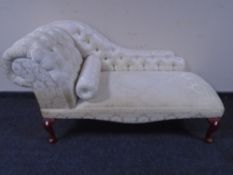 A reproduction miniature chaise longue in classical floral fabric
