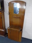 A 20th century oak mirrored hall stand with fitted cupboard.