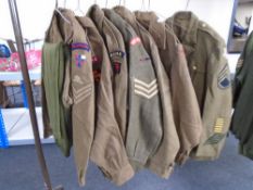 Seven 20th century British army tunics bearing badges together with three pairs of trousers (11)