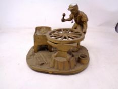 A brass figure of a wheelwright.