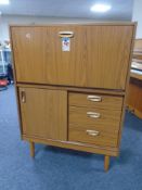 A 20th century teak effect Schreiber secretaire cabinet fitted with cupboard and drawers beneath.
