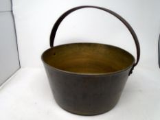 An antique brass jam pan with cast iron handle.
