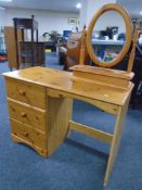 A pine three drawer single pedestal dressing table with mirror and stool together with matching