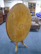 A 19th century inlaid mahogany oval tilt top pedestal tea table.