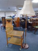 A 20th century teak two tier coffee table together with a teak and brass standard lamp with shade.