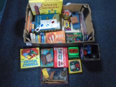 A box containing assorted toys and games including playing cards, board games, Rubiks cube,