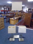 A contemporary brass floor lamp with shade together with a pair of matching table lamps.