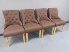 A set of four contemporary reception chairs upholstered in a brown button back fabric.