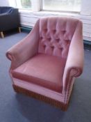 A 20th century armchair upholstered in pink dralon.