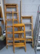Three sets of wooden folding steps.