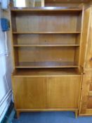 A mid-20th century walnut bookcase with cupboards fitted beneath.
