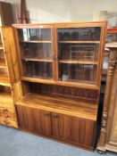 A mid-20th century double door glazed bookcase with cupboards fitted below in a rosewood finish.
