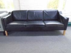 A 20th century Danish three seater settee upholstered in black leather.