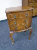 A mahogany bow-fronted three-drawer bedside chest on raised legs