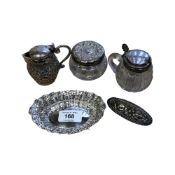 A small pierced silver dish, two silver-lidded pots, a pot lid and an Indian silver jug,