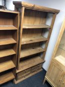 A pine open bookcase fitted with four drawers