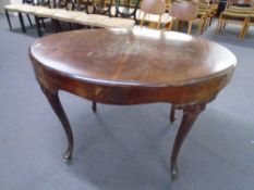 A 19th century mahogany oval dining table on cabriole legs.