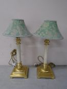 A pair of contemporary brass table lamps with shades.