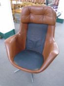 A 20th century brown leather swivel armchair on chrome base (missing cushion).