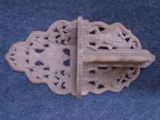 A carved Indonesian wall shelf.