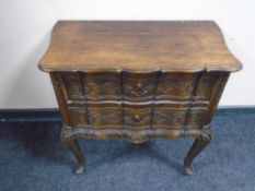 A carved beech two drawer chest on cabriole legs.
