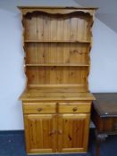 A pine kitchen dresser fitted with drawers beneath