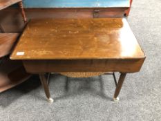 A mid century walnut sewing trolley