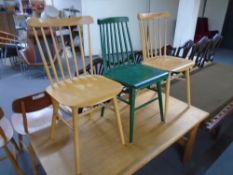 A pair of stick back dining chairs together with a further green stick back dining chair.