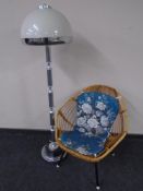 A mid century bamboo and wicker chair on metal legs together with a 1970's standard lamp