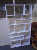 A set of white open bookshelves.