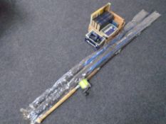 Three fishing rods together with an Okuma fishing reel, books on angling etc.