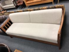 A 20th century Scandinavian wooden framed settee in beige fabric